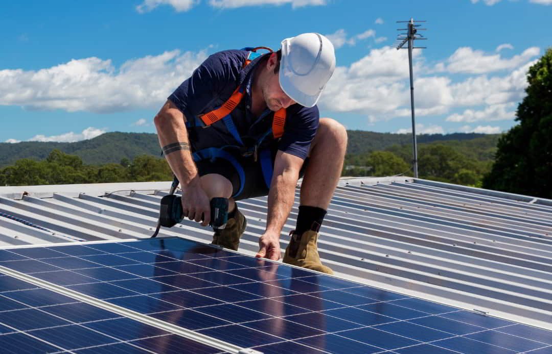 hombre instalando una placa solar en un tejado